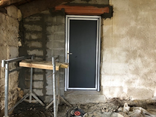 Photo montrant la mise en place d'une nouvelle porte extérieure.